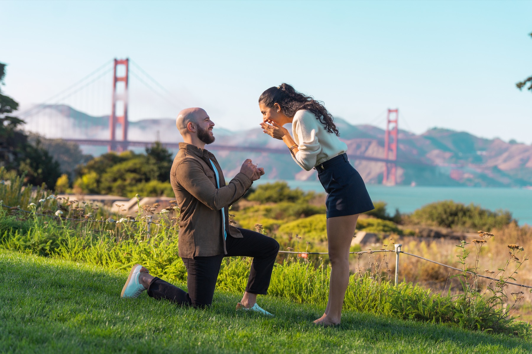 Alex proposing at Battery Bluff Park with the Golden Gate Bridge behind them