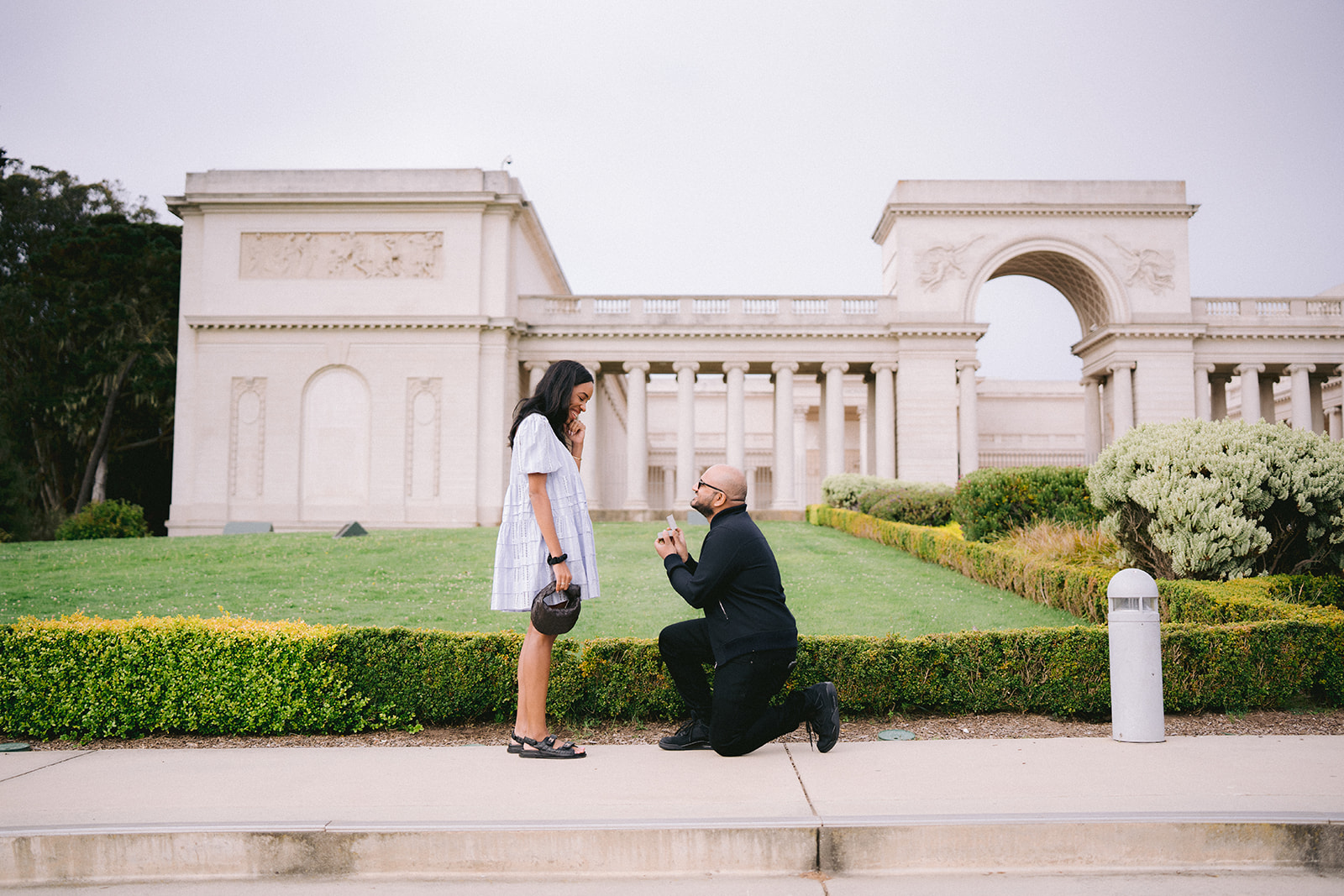 Couple celebrating a surprise proposal at the Legion of Honor in San Francisco