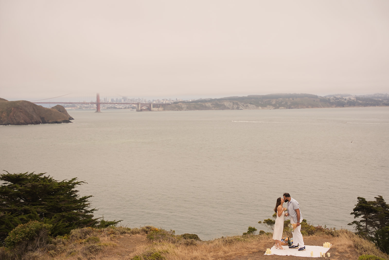 Couple embracing after their Golden Gate Bridge proposal